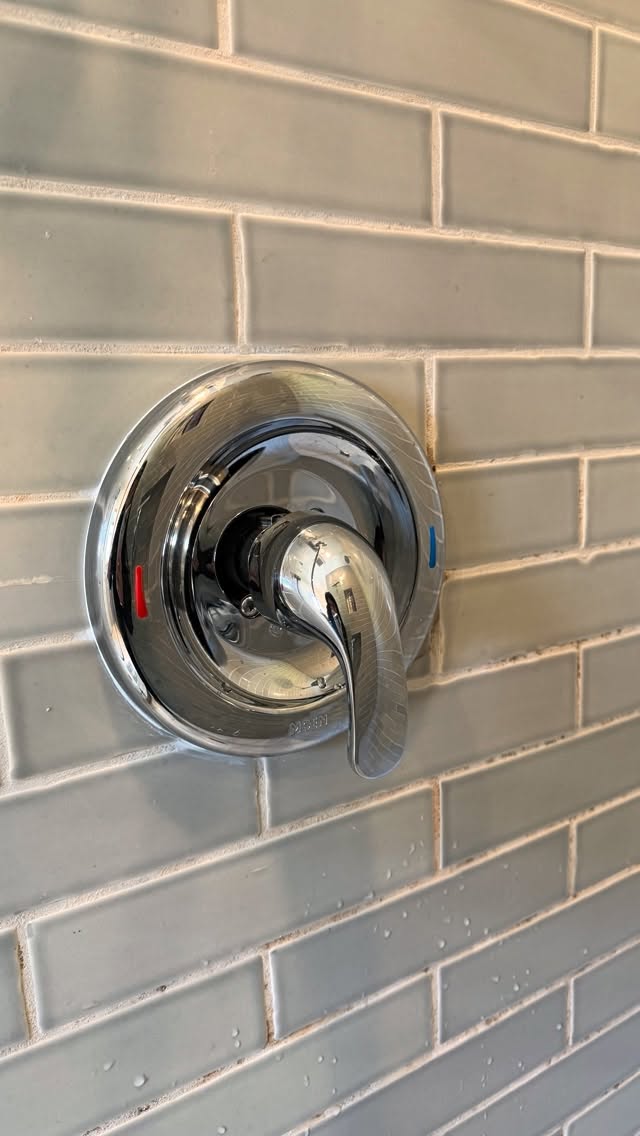 New shower valve trim installed on a tiled wall